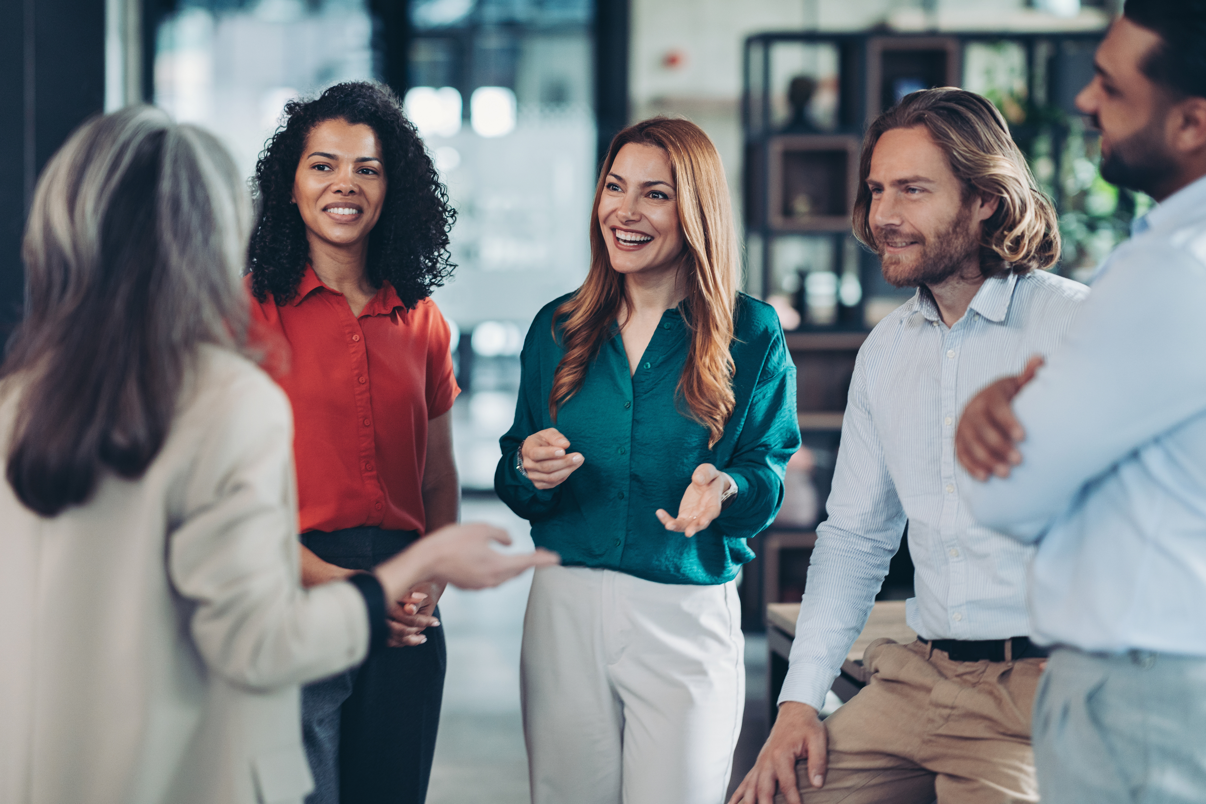 A diverse group of colleagues talking together in a bright workspace